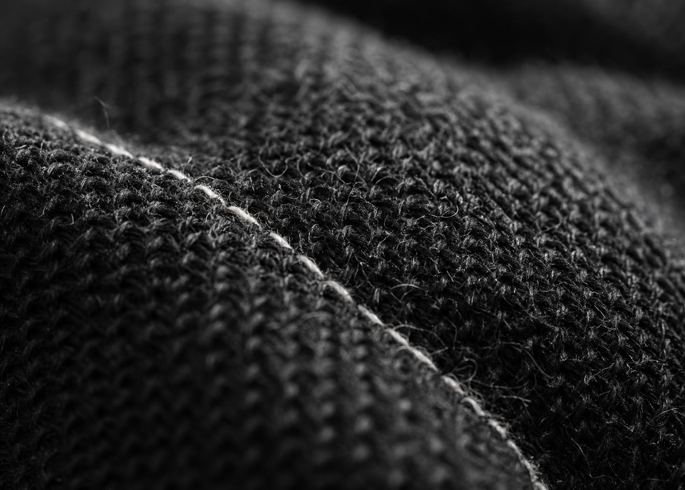 Close-up of dense black EUVRΛN fabric weave and reinforced stitching
