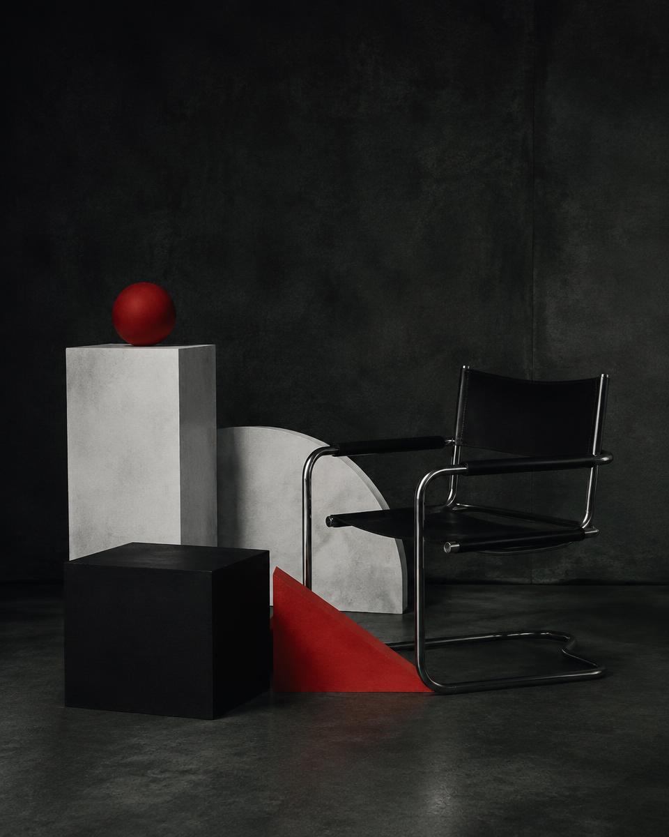 Tubular steel chair beside geometric black, white and red forms