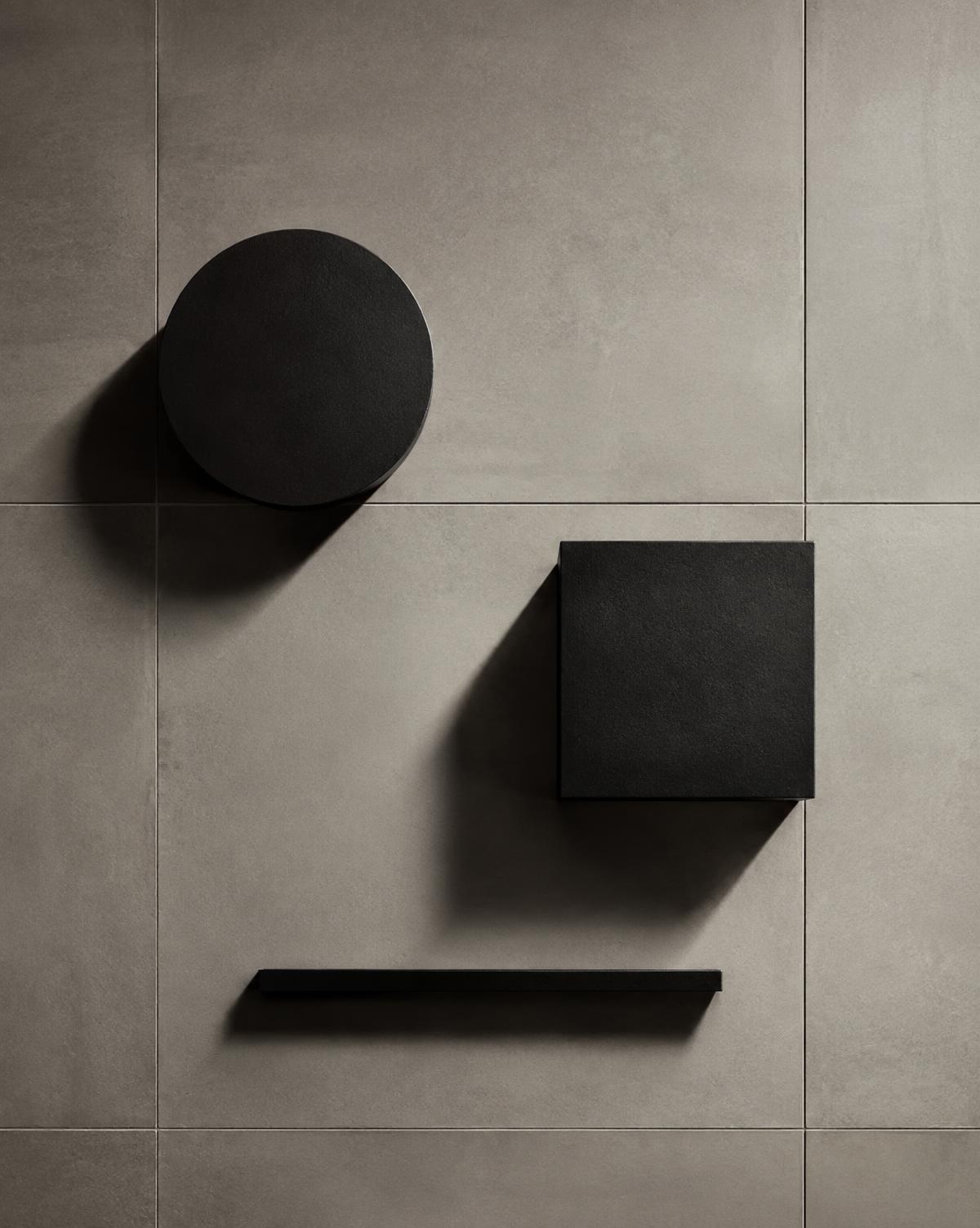 Black circle, square and line on a plaster grid