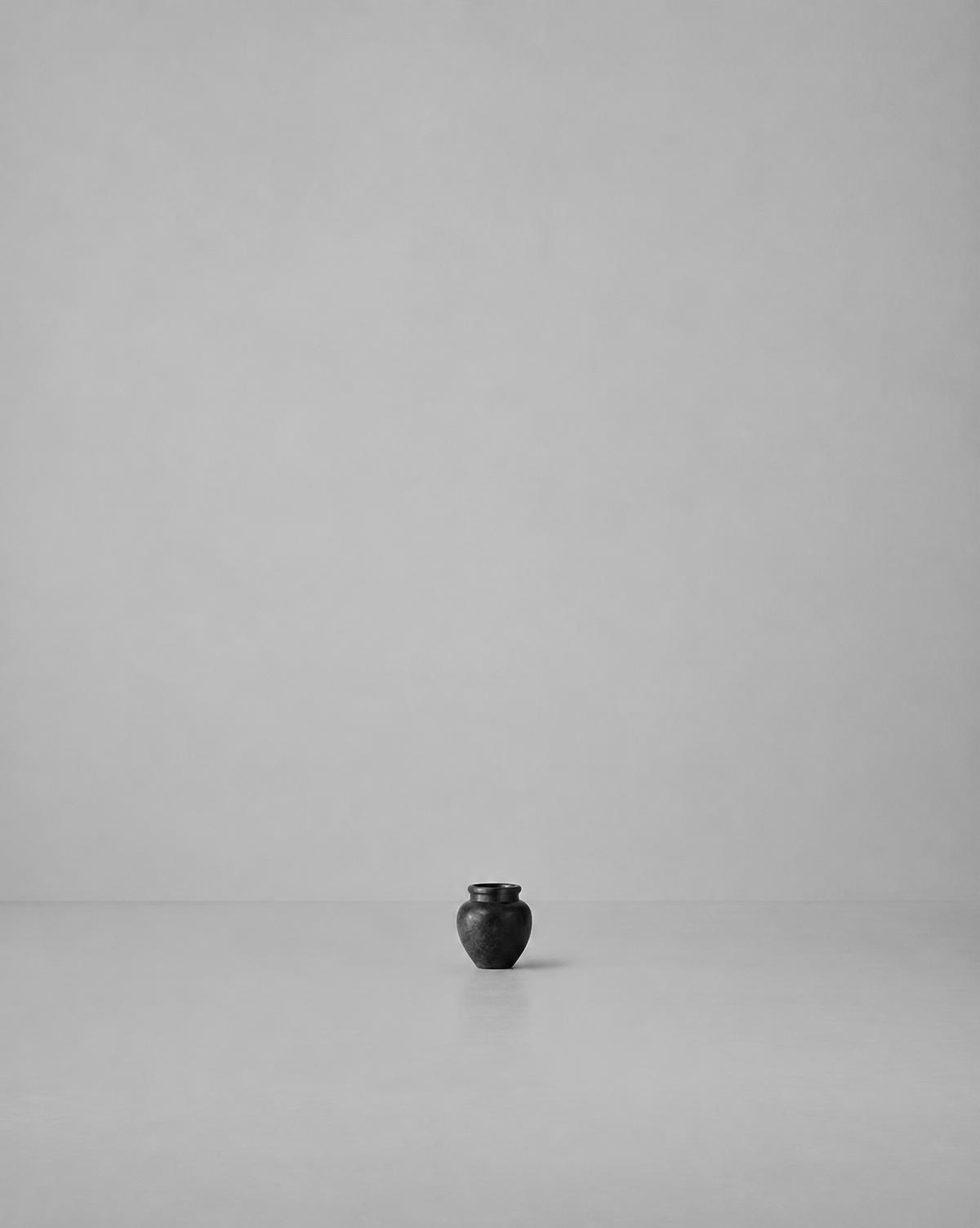A small dark vessel in a large empty grey room