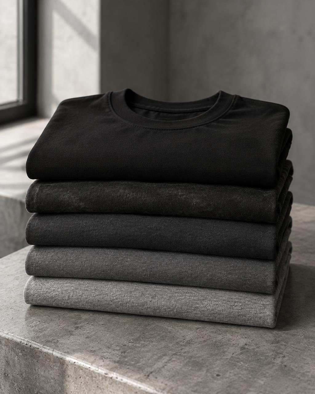 Folded T-shirts in jet black, washed black, charcoal, graphite and dark grey