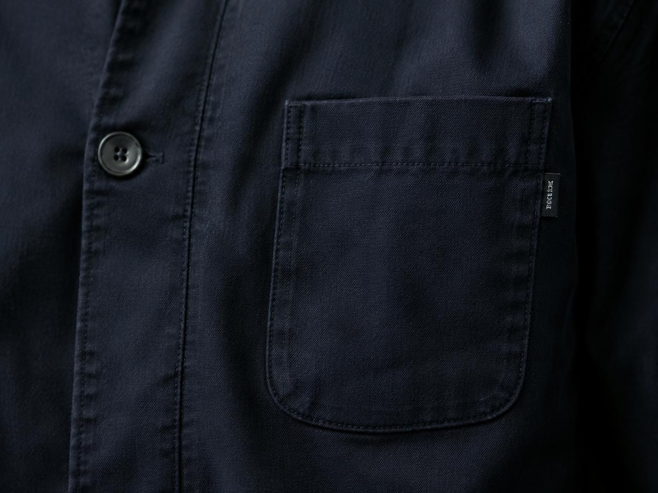A plain button and a functional patch pocket on a navy overshirt