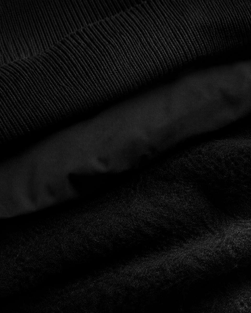 Black ribbed knit, smooth poplin and brushed wool layered together